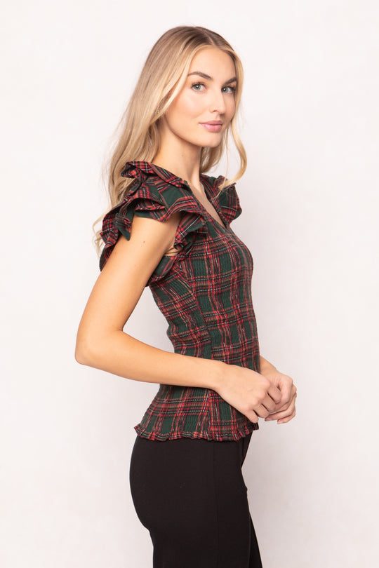 woman is wearing a evergreen plaid top on a white background