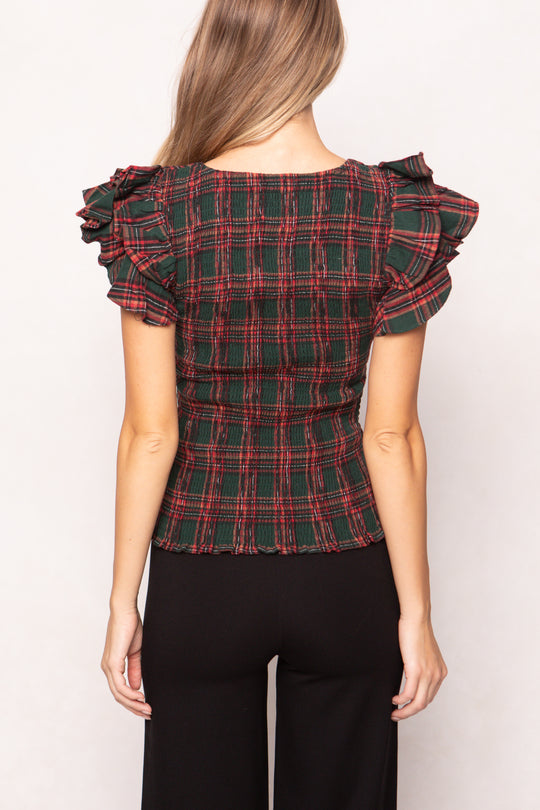 woman is wearing a evergreen plaid top on a white background