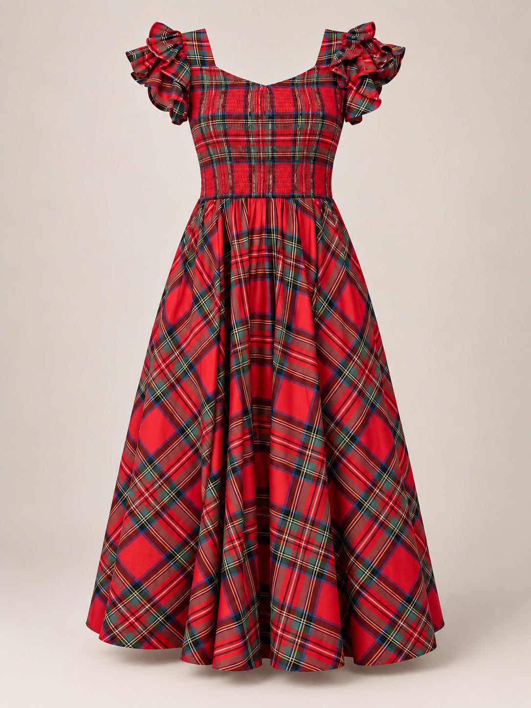 The Hattie Dress in Holiday Plaid by Ivy City Co is a maternity-friendly dress featuring green, blue, and yellow plaid on a red background. Designed with puffed short sleeves, a fitted smocked bodice, and a flared ankle-length skirt, this festive dress combines comfort and style for any special occasion.