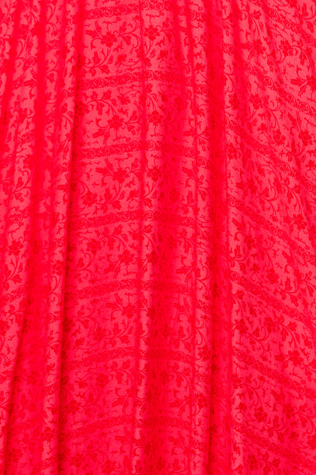 Bright red fabric with a subtle floral vine pattern and gentle vertical pleats—ideal for making the Hattie Dress in Crimson Pink by Ivy City Co or an elegant cotton midi dress.