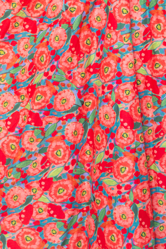 The Hattie Dress in Poppy by Ivy City Co features bright red and pink poppy blooms, green leaves, and blue highlights on cotton—perfect for a lively, cheerful midi-length look.