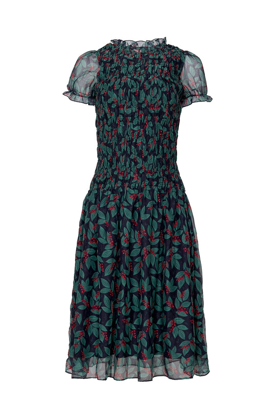 Ivy City Co Hayden Dress in Berries, a mid-length dress with short ruffled sleeves and a smocked bodice, featuring a dark blue print of green leaves and red berries.