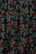 Close-up of fabric with red berry and green leaf pattern on black background