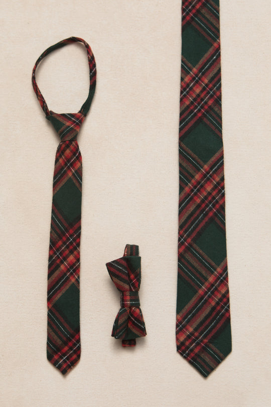 set of different size, green and red plaid ties on a cream background 