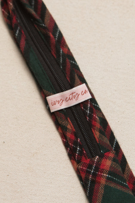 ivy city logo on the back of a green and red plaid tie on a cream background 