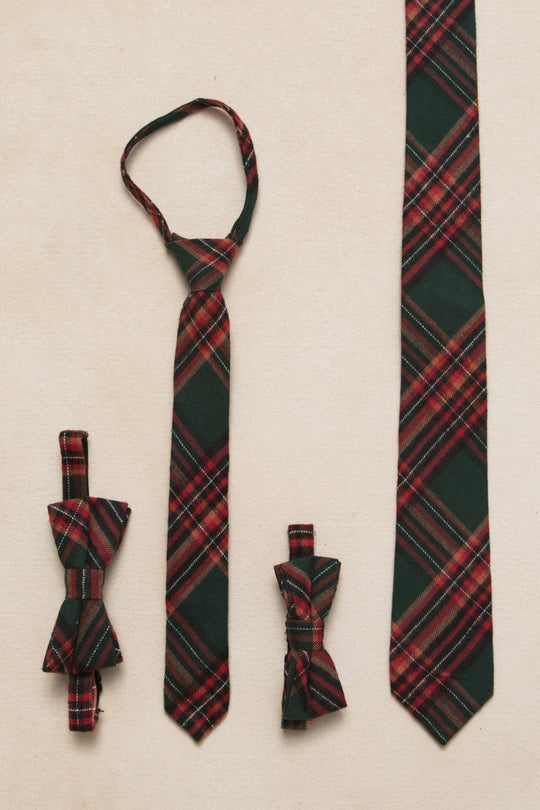 A set of green plaid ties in various styles including a necktie, bow tie, and pre-tied versions, displayed against a neutral background.