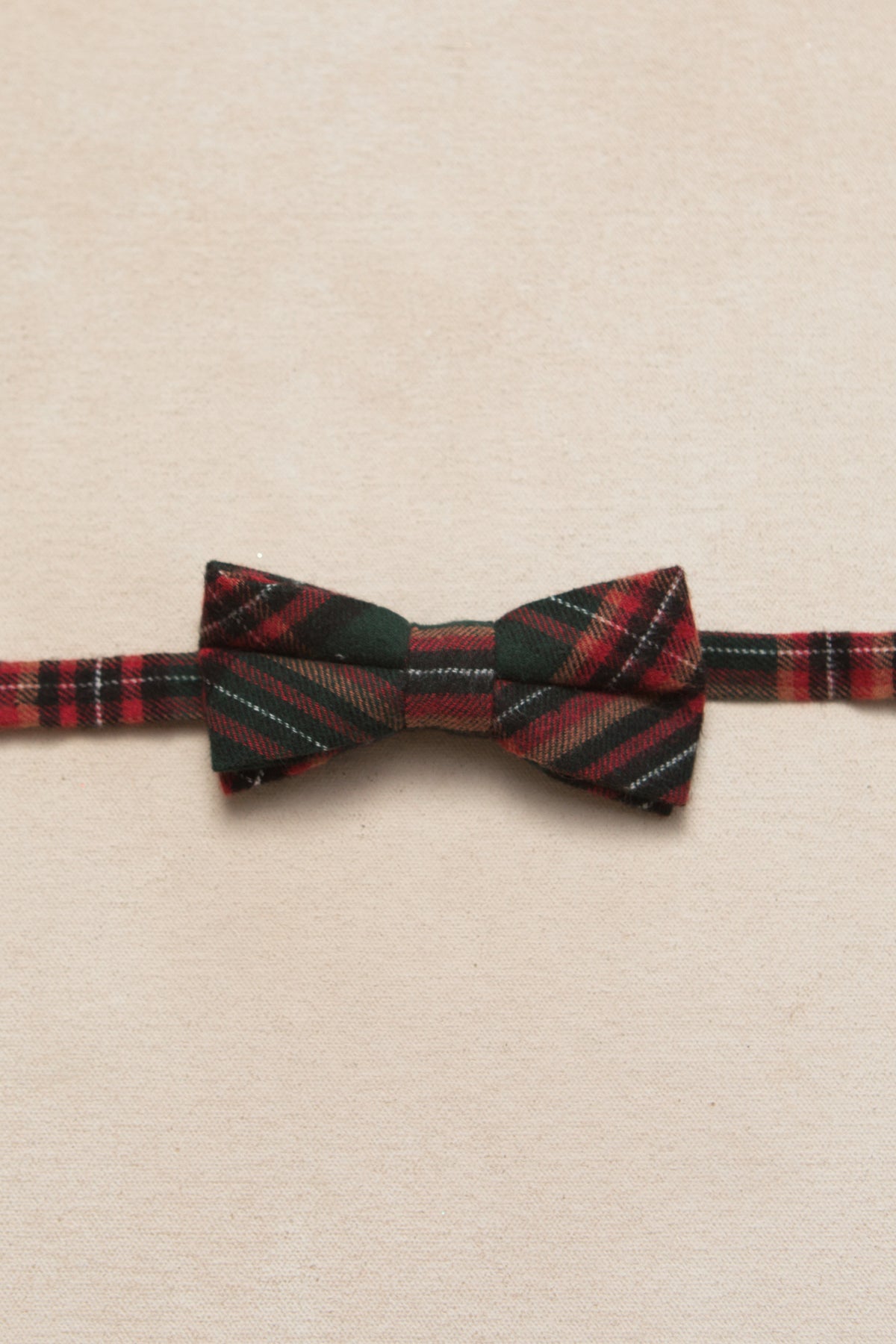 green and red plaid bowtie on a cream background 