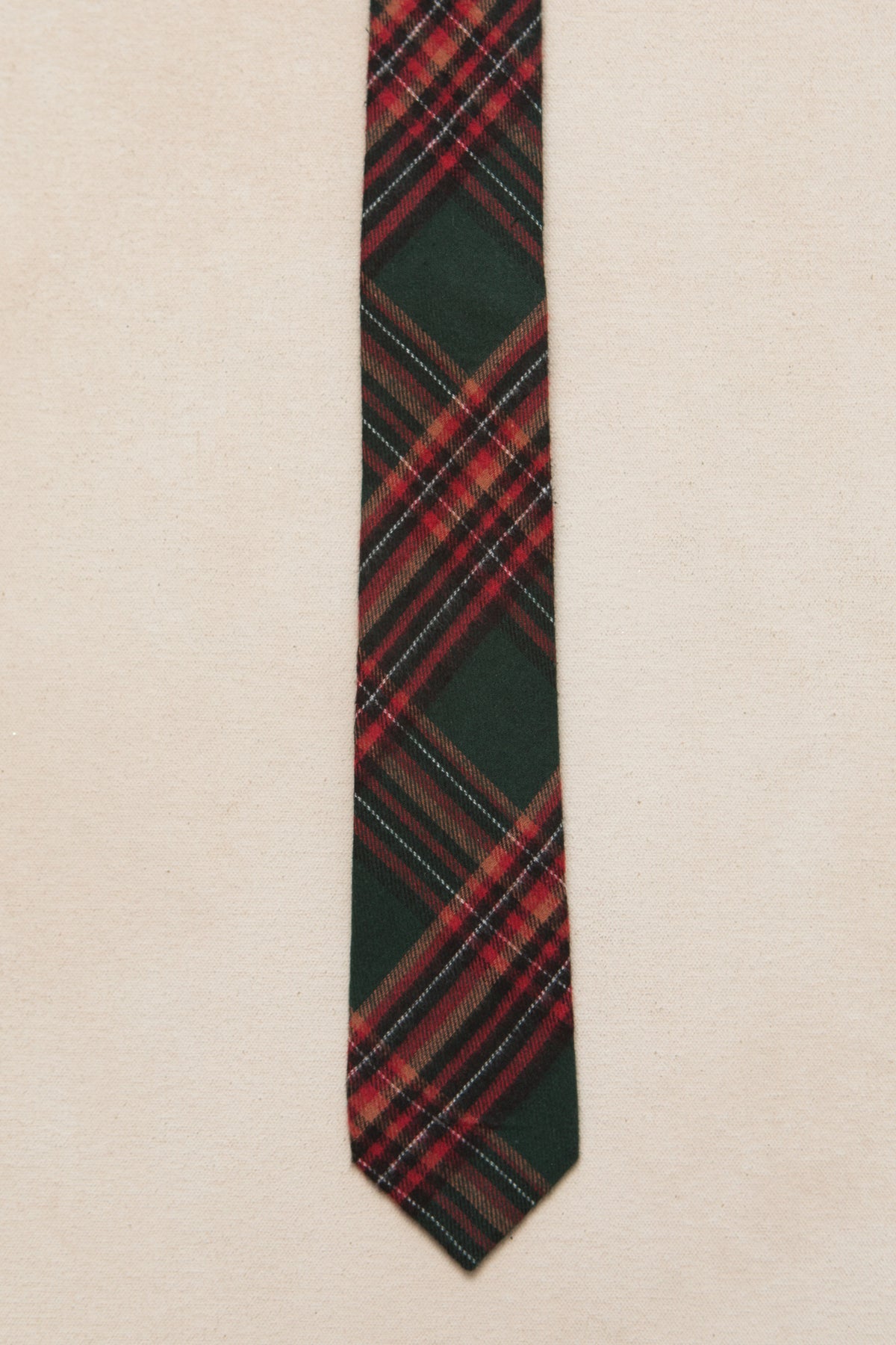 green and red plaid mens tie on a cream background 