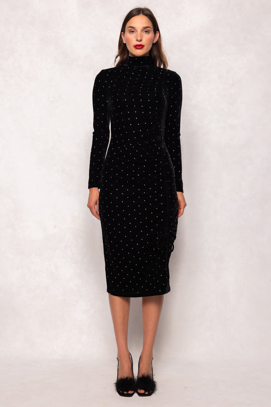 Woman wearing a black polka dot dress against a white background