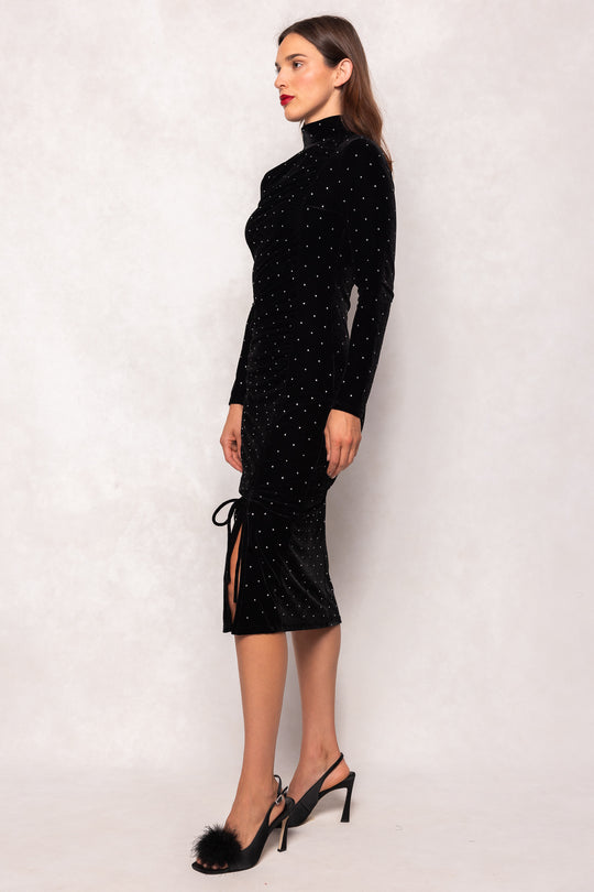 Woman wearing a black dress with a slit on a white background
