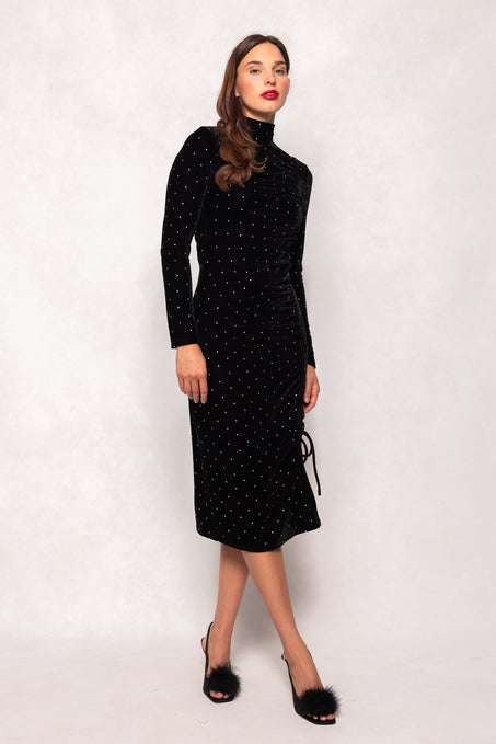 Woman wearing a black polka dot dress against a white background