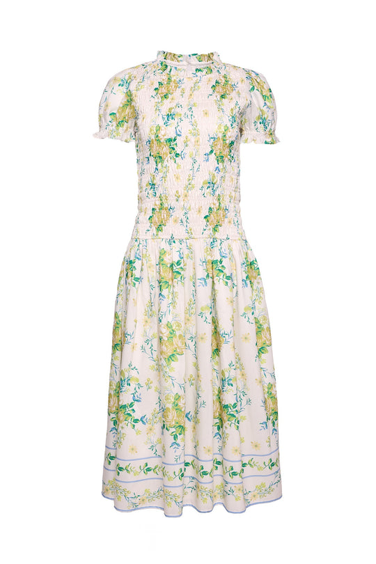 The Jennifer Dress in Garden Tea Party Floral by Ivy City Co is a white, short-sleeved, knee-length dress adorned with a cheerful yellow and green floral pattern. Featuring a fitted bodice, gathered waist, and slightly ruffled high neckline, this maternity-friendly dress is crafted from lightweight fabric for an airy and comfortable fit—making it perfect for warm days and expectant mothers alike.
