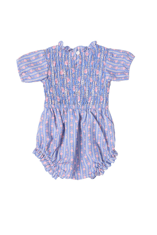 The Baby Mariah Romper in Linear Print by Ivy City Co is a short-sleeved cotton snap romper adorned with blue and pink linear floral patterns. It features a smocked bodice, elastic leg openings, and easy-to-use buttons at the back, making it perfect for stylish comfort.