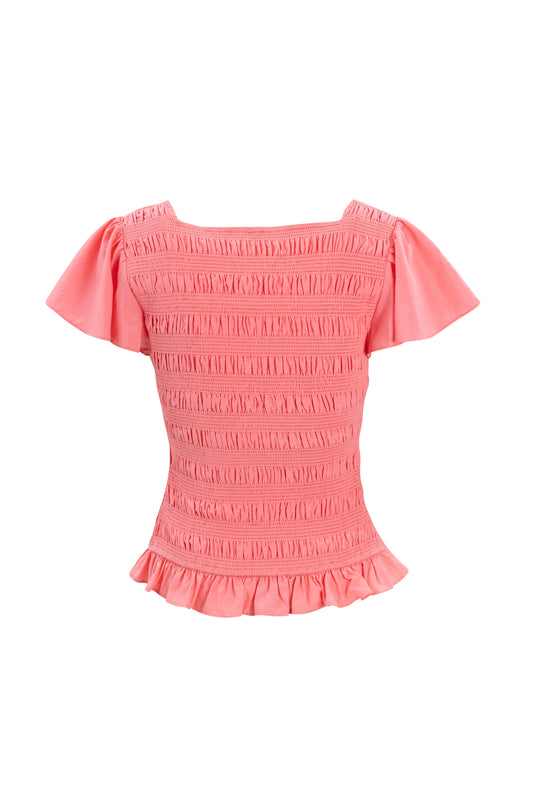 The Janessa Top in Pink by Ivy City Co is a seersucker top with short, slightly flared sleeves, a square neck, smocked details, and a ruffle peplum hem, shown on a white background.