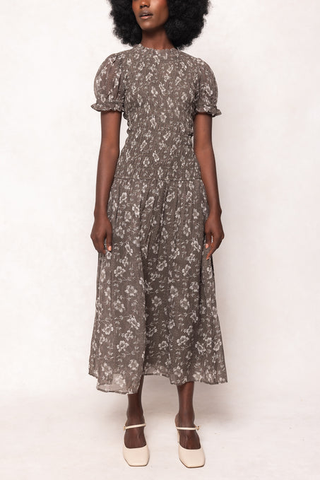 Woman wearing a floral dress against a white background