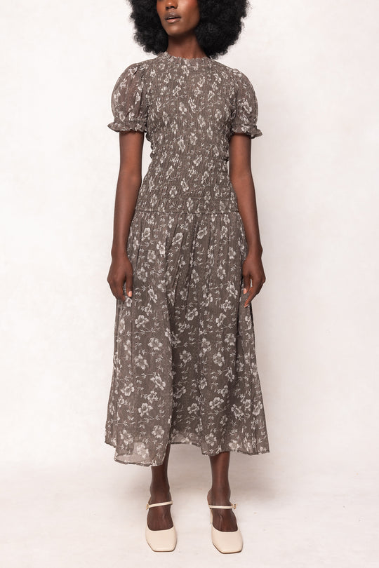 Woman wearing a floral dress against a white background