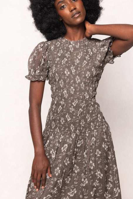 Woman wearing a floral dress against a white background