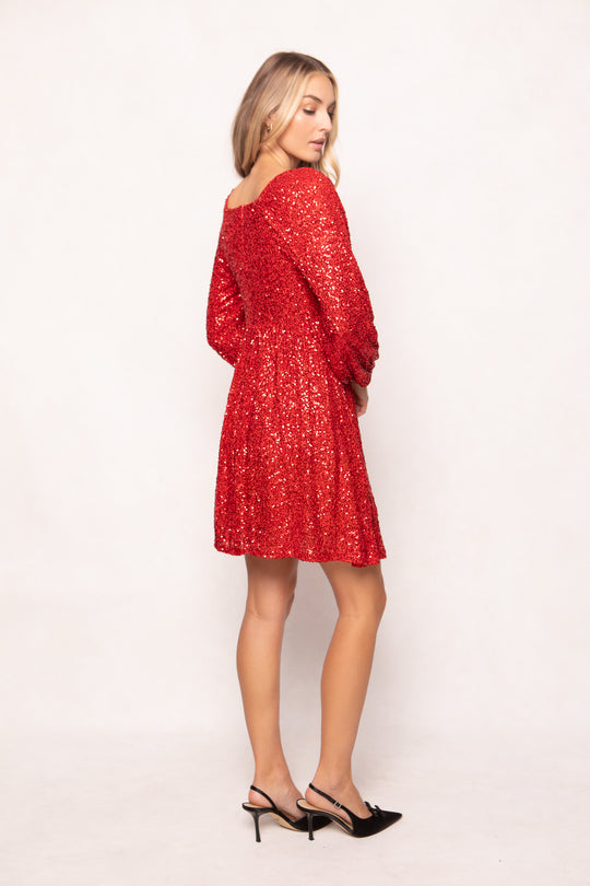 Woman wearing a red sequin dress against a white background