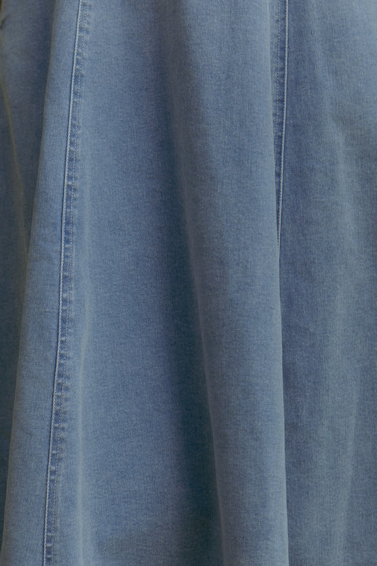 Close-up of the Joanna Dress in Denim by Ivy City Co, featuring maternity-friendly light blue denim fabric with a vertical seam and soft folds.