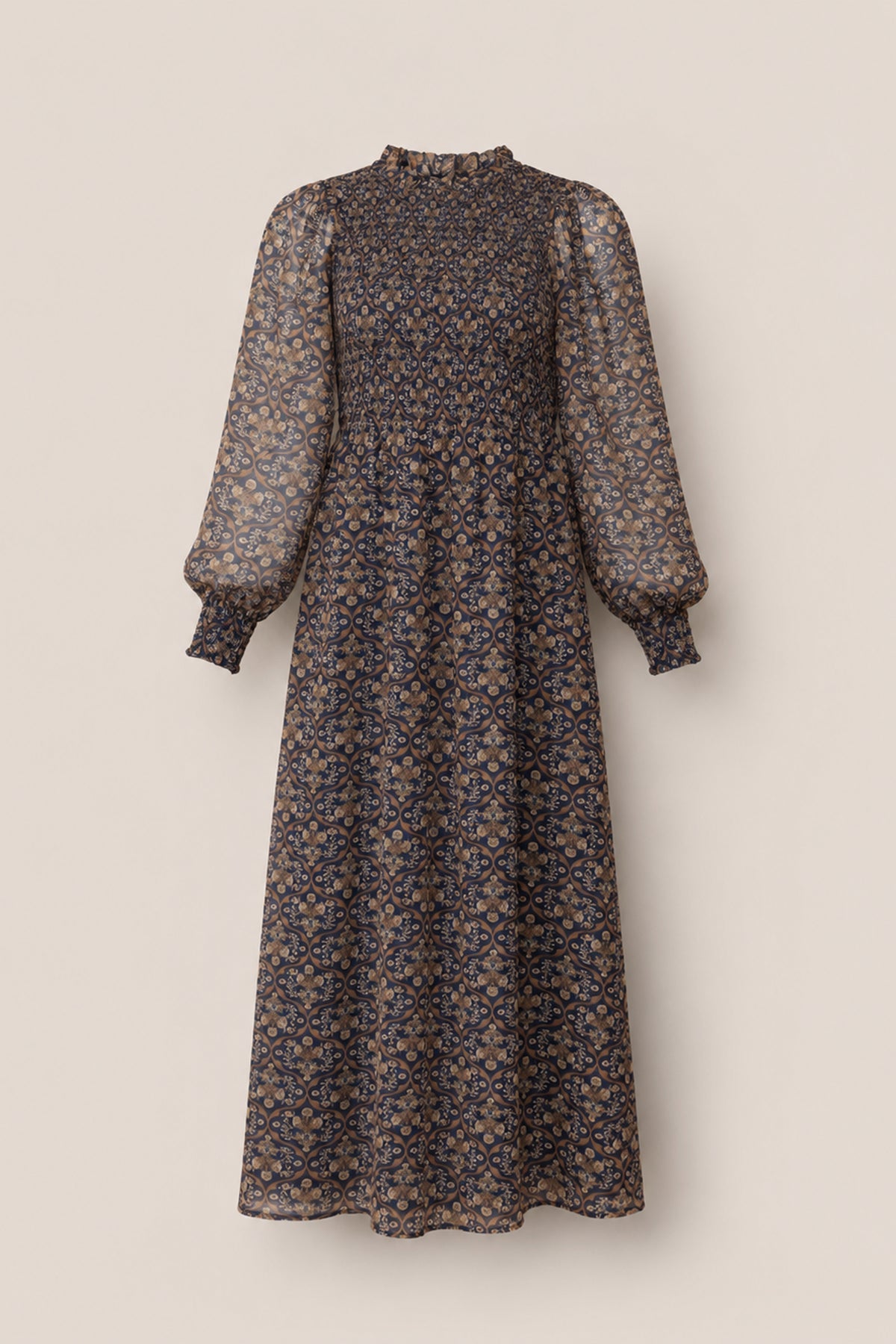 The Jordan Dress in Midnight Moroccan Tile by Ivy City Co is an ankle-length maxi dress featuring long balloon sleeves, a high ruffled neckline, and a striking blue and tan floral paisley pattern on sheer fabric—an elegant choice for evening wear or making a statement at any special occasion.
