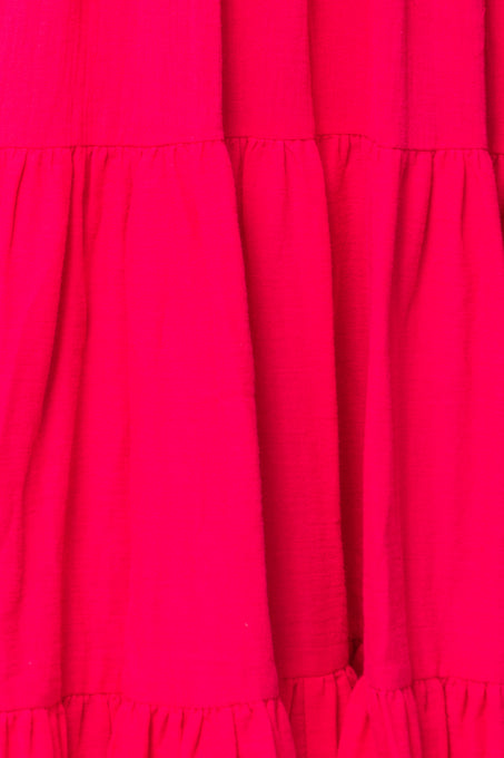Close-up of the Jovie Midi Dress in Hot Pink by Ivy City Co, featuring soft, lightweight cotton with bright pink tiered fabric and gathered ruffled seams for a playful, vibrant look.