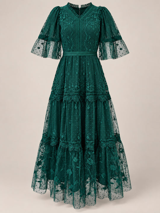 The Jules Dress in Emerald by Ivy City Co is a stunning emerald green maxi dress, featuring puffed sleeves, a tiered skirt, floral embroidery, and sheer ruffle details. This elegant holiday dress showcases a V-neckline and fitted waist—making it an ideal choice for festive gatherings.