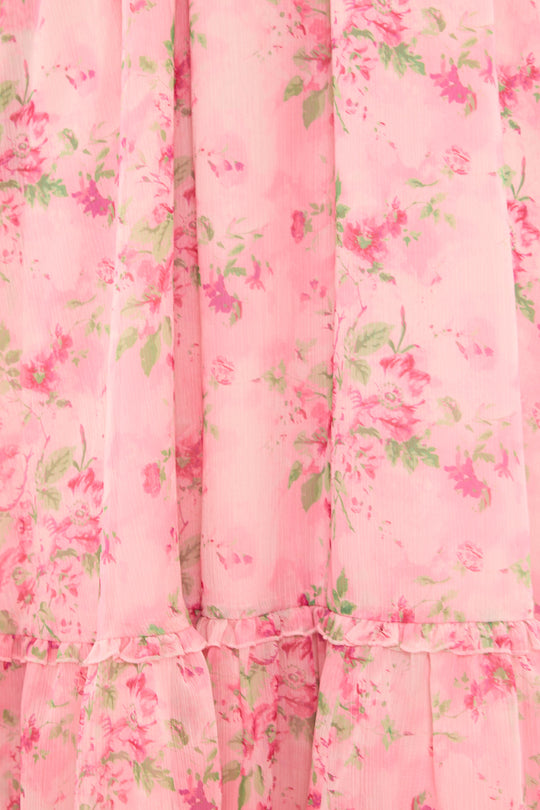 Close-up of a pink floral dress with ruffled layers.