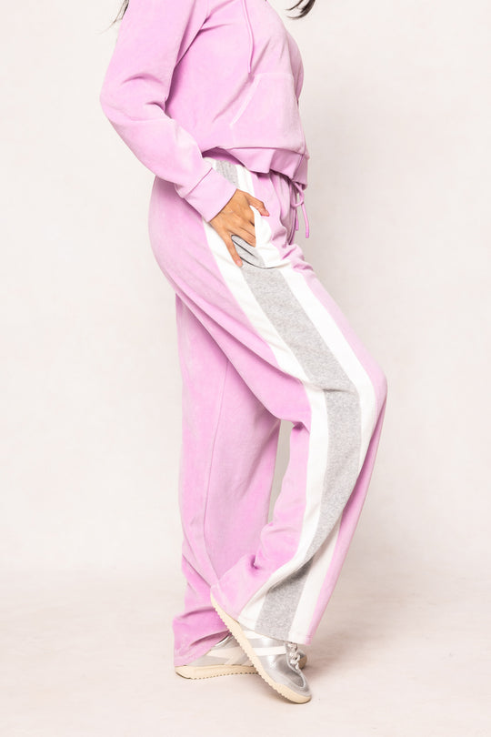 Woman in a pink sweatsuit against a white background