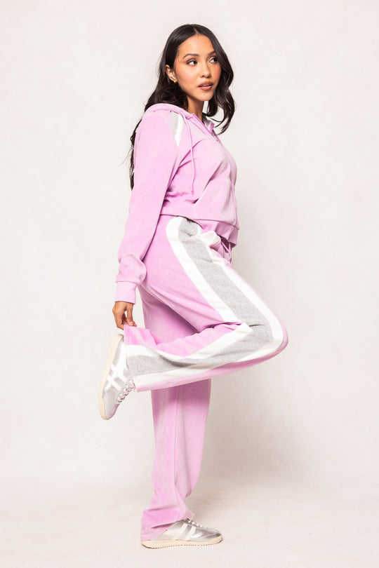 Woman in a pink sweatsuit against a white background