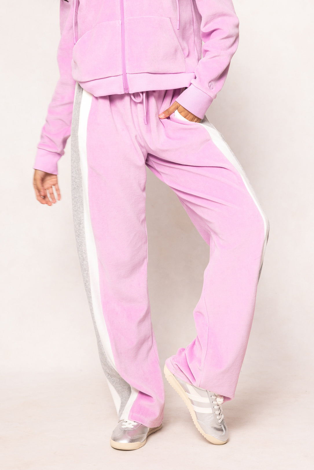 Woman in a pink sweatsuit against a white background