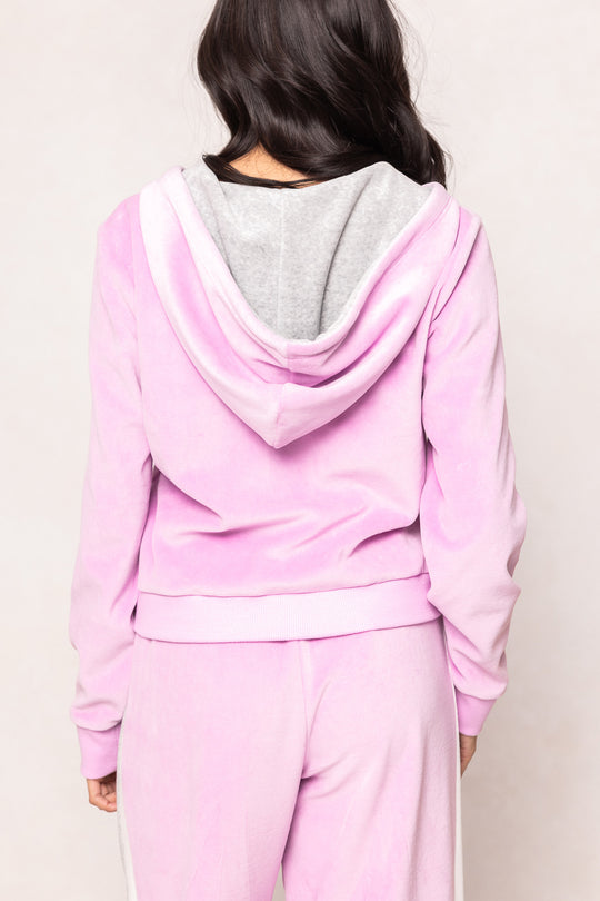 woman in a pink sweatsuit against a white background