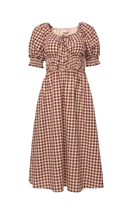 The Kaitlyn Dress in Chocolate Gingham features a midi length, short puffed sleeves, a fitted smocked bodice, and a gathered neckline with center tie—creating a charming, maternity-friendly silhouette.