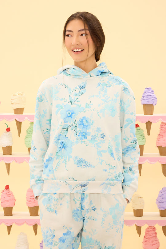 Person wearing a floral hoodie and pants with ice cream cone background