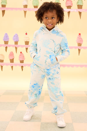 child wearing a blue floral hoodie against a yellow ice cream cone wall