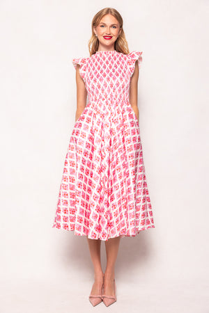Woman wearing a pink and white patterned dress against a light background
