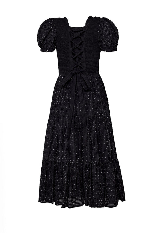 Introducing the Darby Dress in Black Diamonte by Ivy City Co—a chic, maternity-friendly black midi dress featuring tiered layers, puff sleeves, a subtle polka dot pattern, and a lace-up corset-style back with a delicate bow. This timeless style blends elegance and comfort for any occasion.