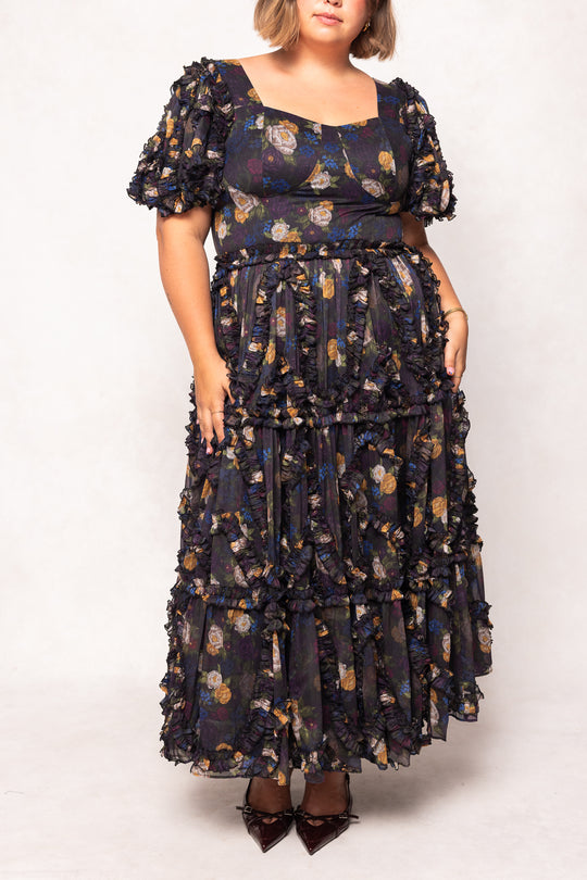 Woman wearing a dark floral dress on a white background