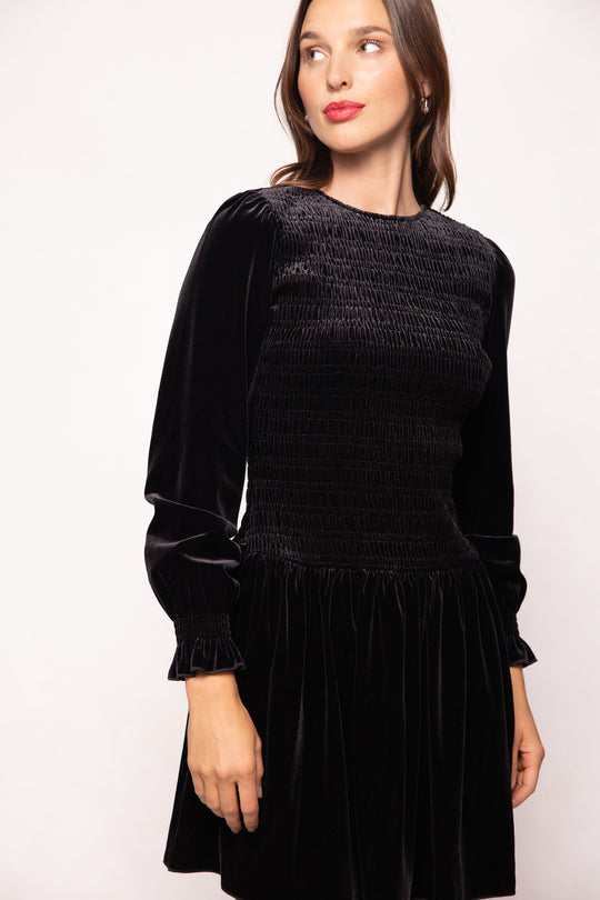 Woman wearing a black dress against a white background