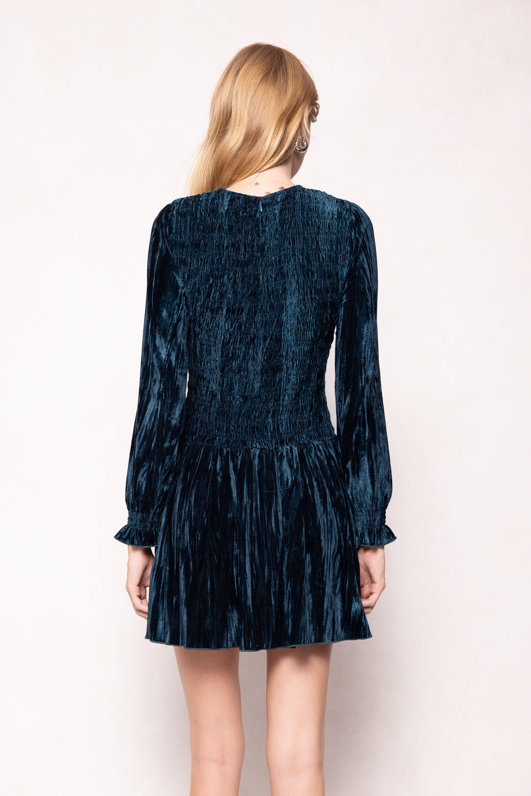 Person wearing a dark blue textured dress on a white background
