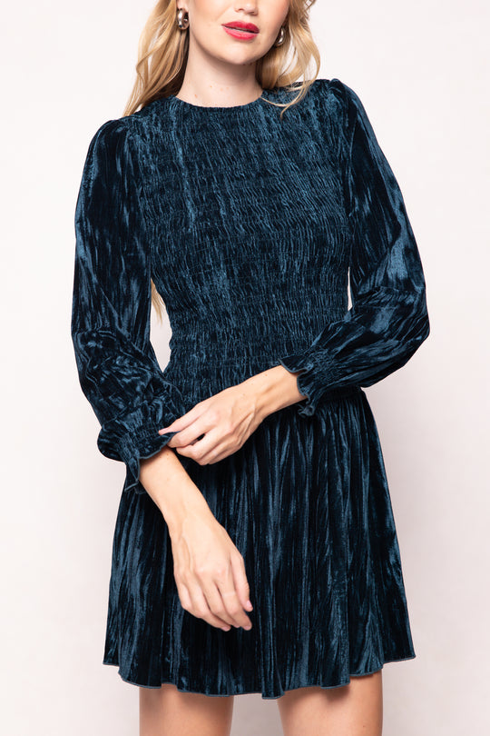 Woman wearing a dark blue velvet dress against a white background