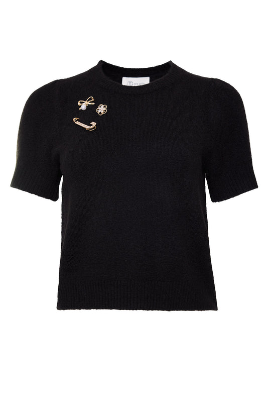 black sweater with gold pin detail against a white background
