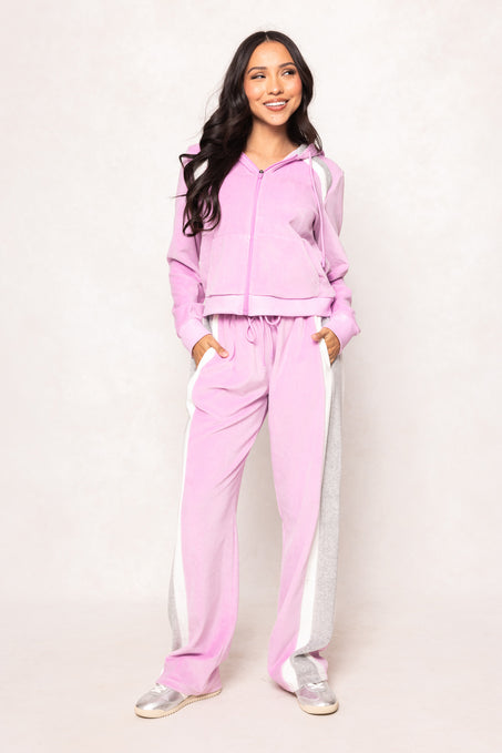 woman in a pink sweatsuit against a white background