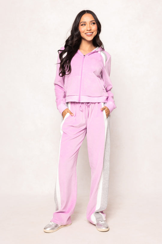 Woman in a pink sweatsuit against a white background