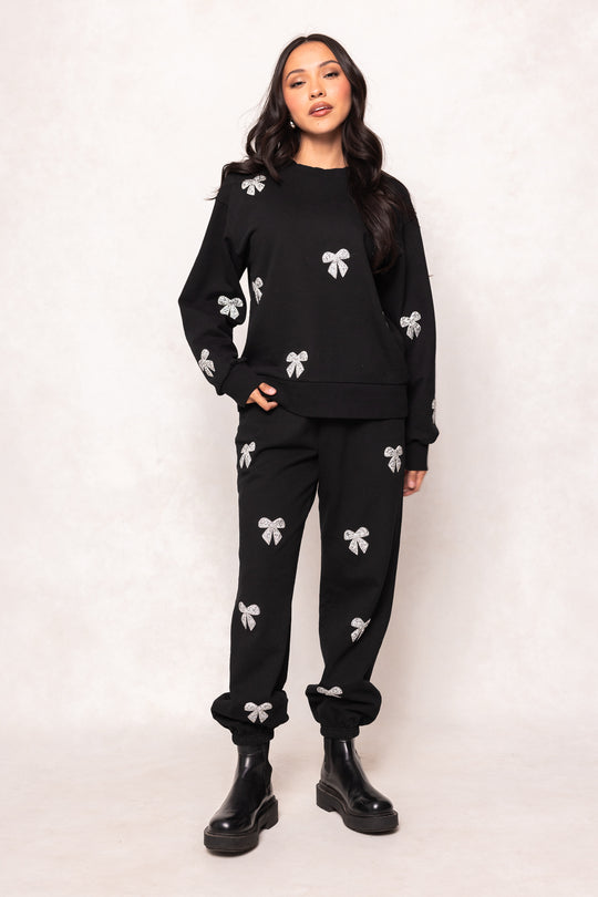 Woman wearing a black outfit with white patterns on a white background