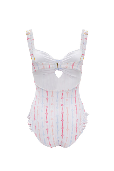 The Ivy City Co Lucy One Piece in Breea Bow features white fabric with pink and blue stripes, supportive straps, a front keyhole cutout, gold buckle at the bust, and subtle ruffle accents at the sides for a playful look.