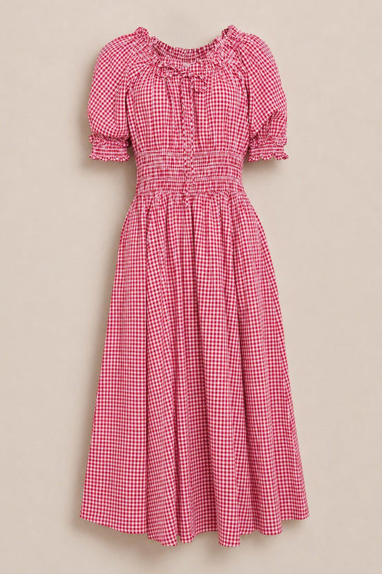The Jessie Dress in Red Gingham by Ivy City Co features short puff sleeves, a fitted smocked waist, and a knee-length skirt, shown against a beige background—an ideal nursing-friendly option that combines comfort with timeless style.