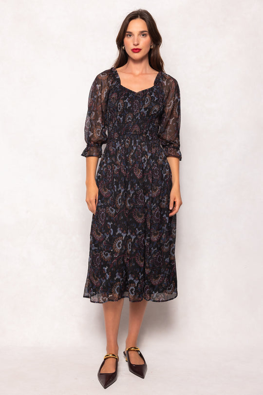 Woman wearing a dark floral lace dress on a white background