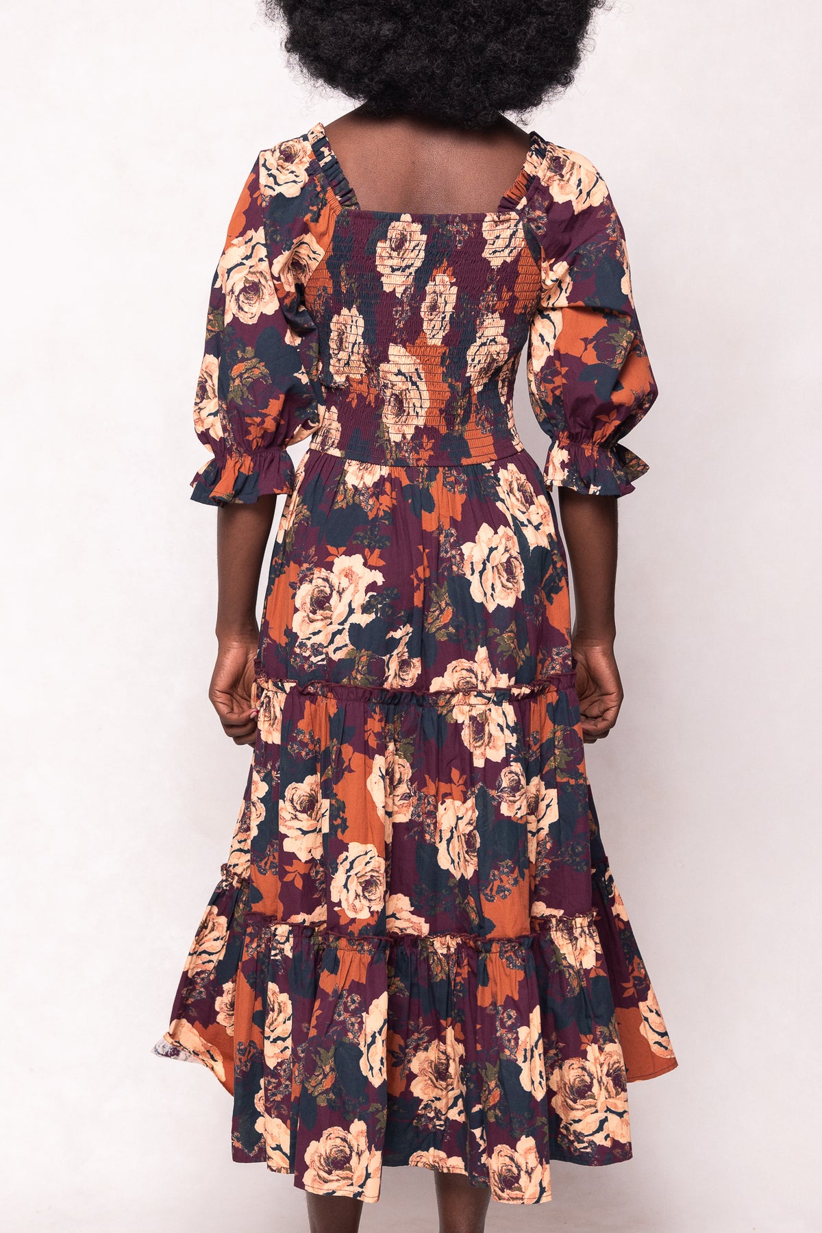 Floral dress with ruffled sleeves worn by a person on a white background