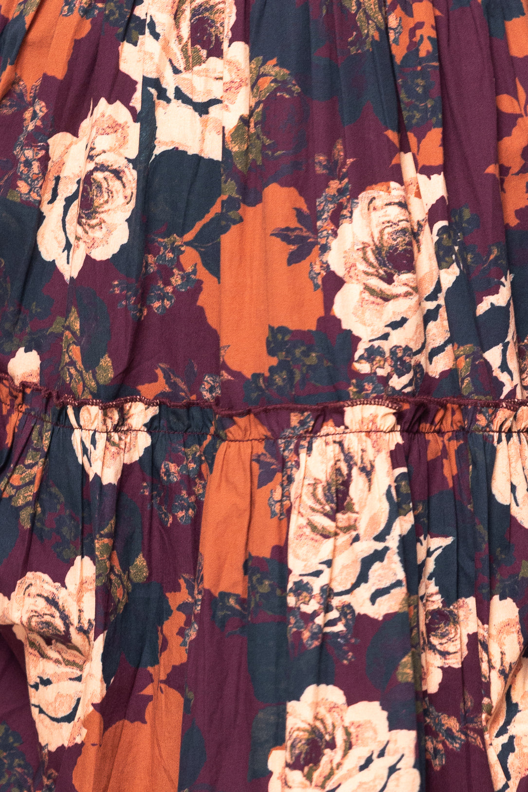 Close-up of a floral dress with a mix of colors including orange, purple, and white.