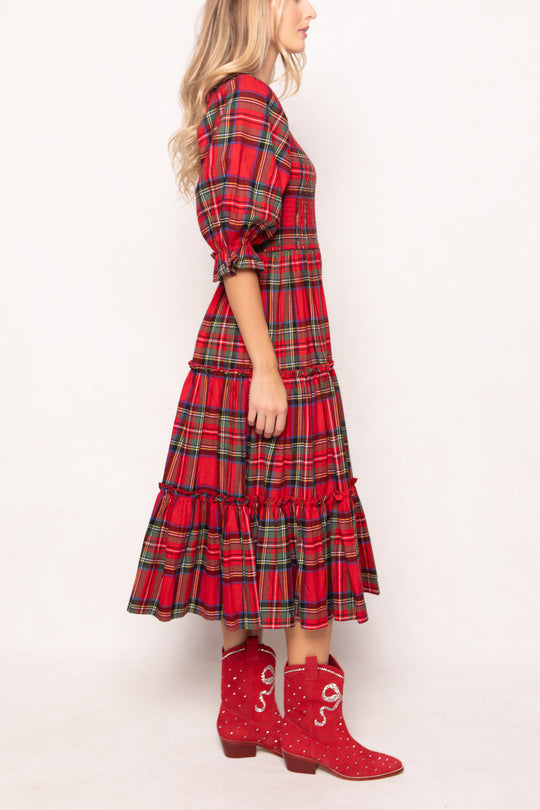 woman in a red plaid dress with red boots on a white background 